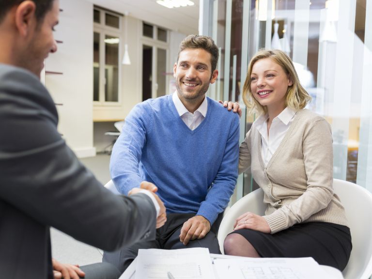 Man and woman discussing rental property with their professional letting agent - shaking hands 